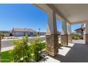 Inviting porch with stone columns and manicured plants creating a welcoming entry to the home at 17336 W Crawfordsville Dr, Surprise, AZ 85388