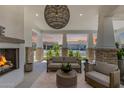 Cozy outdoor living space with a fireplace, comfortable seating, and neighborhood views at 17336 W Crawfordsville Dr, Surprise, AZ 85388