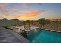 Beautiful backyard pool area features lounge chairs, a fire pit, and a water feature at 17336 W Crawfordsville Dr, Surprise, AZ 85388