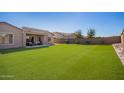 This spacious backyard features artificial grass and a covered patio at 18406 W Verbena Dr, Goodyear, AZ 85338