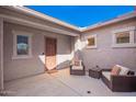 Private courtyard with cushioned seating, neutral color scheme, and a welcoming entrance at 18406 W Verbena Dr, Goodyear, AZ 85338