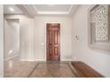 Inviting foyer with decorative tile, dark wood door, bench seating, and elegant lighting at 18406 W Verbena Dr, Goodyear, AZ 85338