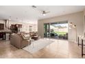 Open-concept living room featuring a leather sectional, tile flooring, and backyard access at 18406 W Verbena Dr, Goodyear, AZ 85338