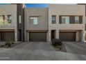Contemporary townhome showcasing a modern facade with stone accents and individual two-car garages at 1941 W Trotter Trl, Phoenix, AZ 85085