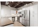 Modern kitchen with stainless steel appliances, granite countertops, and white cabinets with an exposed ceiling at 2 W Georgia Ave # 5, Phoenix, AZ 85013