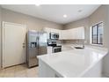 Well-lit kitchen with stainless steel refrigerator, updated appliances, and bright countertop at 2051 W Ronald Rd, Phoenix, AZ 85029