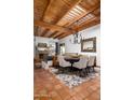 Dining room featuring a wood beam ceiling, tiled floors, and a stylish chandelier at 2548 E Vermont Ave, Phoenix, AZ 85016