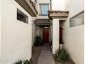Inviting entryway with a red front door, desert landscaping and warm, neutral stucco walls at 2992 N Miller Rd # 219B, Scottsdale, AZ 85251