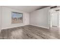 Inviting living room with a large window, new gray floors and lots of natural light at 3120 N 67Th Ln # 96, Phoenix, AZ 85033