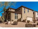 A two-story home featuring a side-entry garage, desert landscaping, and a tile roof at 32405 N 23Rd Ave, Phoenix, AZ 85085