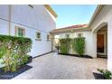 Private courtyard with pavers, a black iron gate, lush greenery, and access to the main house at 3370 S Ivy Way, Chandler, AZ 85248