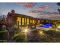 Beautiful home featuring a built-in grill and bar adjacent to a pool with bright illumination and a wonderful night view at 3654 E San Pedro Pl, Chandler, AZ 85249