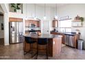 Well-equipped kitchen with stainless steel appliances, island with seating, and ample cabinet space at 41250 W Thornberry Ln, Maricopa, AZ 85138