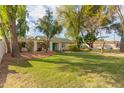 Beautiful single-story home with a lush green lawn, mature trees, and manicured landscaping at 430 N Vineyard --, Mesa, AZ 85201