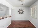 Bright dining area featuring wood floors, a decorative wall mirror, and a pass-through to the kitchen at 7327 N 21St Ave, Phoenix, AZ 85021