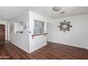 Bright dining area featuring wood floors, a decorative wall mirror, and a pass-through to the kitchen at 7327 N 21St Ave, Phoenix, AZ 85021