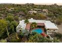 Expansive aerial view showcasing the property's pool, landscaping, and surrounding desert landscape with mountain views at 7451 E Long Rifle Rd, Carefree, AZ 85377