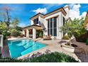 Exterior view of a home and pool, featuring a private pool, patio, and well-manicured landscaping at 7667 E Krall St, Scottsdale, AZ 85250