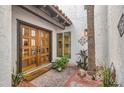 Inviting entryway with wooden double doors, a 'Welcome' mat, and elegant landscaping at 77 E Missouri Ave # 7, Phoenix, AZ 85012