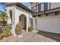 Charming home exterior showcasing an arched doorway, a private balcony, and a two car garage at 77 E Missouri Ave # 7, Phoenix, AZ 85012