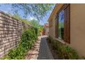 Paver walkway with lush green plants leading up to the charming home at 12098 W Lone Tree Trl, Peoria, AZ 85383
