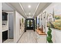 Elegant hallway with decorative wall art, mirrors, and views of the front entry at 12539 W Tuckey Ln, Glendale, AZ 85307