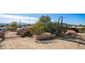 A gated driveway leads to a home with a desert landscape and mature trees at 13023 N Joan D Arc Ave, Phoenix, AZ 85032