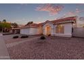 Charming single-story home featuring a three-car garage, desert landscaping and an arched entry at 1470 S Villas Ct, Chandler, AZ 85286