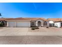 Charming single-story home featuring a three-car garage, desert landscaping and a red tile roof at 1470 S Villas Ct, Chandler, AZ 85286