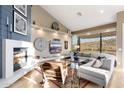 Bright living room with a fireplace, contemporary furnishings, and a large window showcasing desert views at 16341 E Links Dr, Fountain Hills, AZ 85268