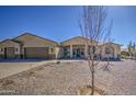 Single story desert home with a three car garage, brick-paved driveway and desert landscaping at 1727 E Hidalgo St, Apache Junction, AZ 85119