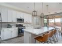 Bright kitchen featuring white cabinets, stainless steel appliances, and a large island with bar seating at 25930 N Thornhill Dr, Peoria, AZ 85383