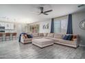 Spacious living room featuring luxury flooring and a large sectional sofa with backyard access at 25930 N Thornhill Dr, Peoria, AZ 85383