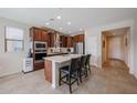 Kitchen features a center island with barstool seating, stainless steel appliances, and pendant lighting at 26955 W Adam Ave, Buckeye, AZ 85396