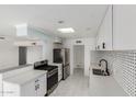 Updated kitchen boasts stainless steel appliances, modern countertops, and ample cabinet space and view to living room at 6767 N 7Th St # 212, Phoenix, AZ 85014
