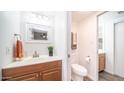 Bright bathroom with wood vanity, decorative mirror, and separate toilet room at 7928 N 46Th Ave, Glendale, AZ 85301
