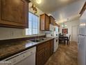 Functional kitchen showcasing wooden cabinetry, a stainless steel sink, and white appliances, adjacent to a dining area at 8700 E University Dr # 1024, Mesa, AZ 85207