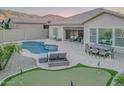 Backyard with a swimming pool, putting green, covered patio, and mountain views at 8911 S 14Th Way, Phoenix, AZ 85042