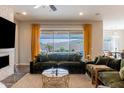 Living room with a fireplace, plush sofas, large windows with backyard views, and hardwood floors at 8911 S 14Th Way, Phoenix, AZ 85042