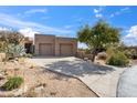 Beautful southwest-style home showcasing a two-car garage, desert landscaping, and a concrete driveway at 9110 E Clubhouse Ct # 639, Scottsdale, AZ 85262