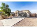 Beautiful single-story home with a large driveway and a two-car garage at 11230 E Cliffrose Ln, Florence, AZ 85132