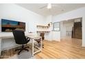 Well-lit home office with sleek desk, floating shelves, and a view of the staircase at 12118 W Villa Chula Ct, Sun City, AZ 85373