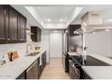 Modern kitchen featuring stainless steel appliances, quartz countertops, and dark wood cabinetry at 1517 E Dunbar Dr, Tempe, AZ 85282