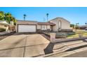 Front exterior of single Gathering home showing desert landscaping, attached garage and gated front yard at 1565 W Plana Ave, Mesa, AZ 85202