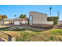 Low angle view of front exterior displaying desert landscaping, palm trees and an attached two-car garage at 1565 W Plana Ave, Mesa, AZ 85202