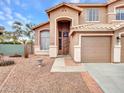 Inviting entrance to home featuring desert landscaping, a three-car garage, and a covered front door at 15819 W Ripple Rd, Goodyear, AZ 85338