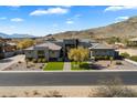 Expansive aerial view of modern home, showing landscaping, desert surroundings and mountain views at 16908 S 31St Ln, Phoenix, AZ 85045