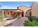 Secluded outdoor courtyard with desert landscaping, comfortable seating, and covered patio at 18683 N 101St Pl, Scottsdale, AZ 85255