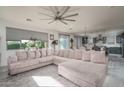 Open-concept living room featuring a large comfortable sofa, an airy feel, and an adjacent eat-in kitchen at 18811 W San Miguel Ave, Litchfield Park, AZ 85340