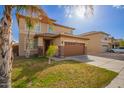 Beautiful two-story home featuring a brown garage door, desert landscaping, and mature trees at 3127 W Apollo Rd, Phoenix, AZ 85041